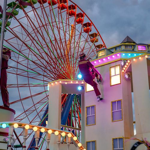A hotel themed parade float with acrobatic bellhops