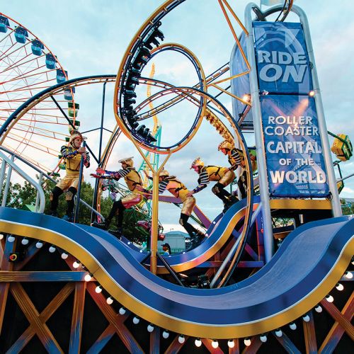 A rollercoaster themed parade float with a skating team