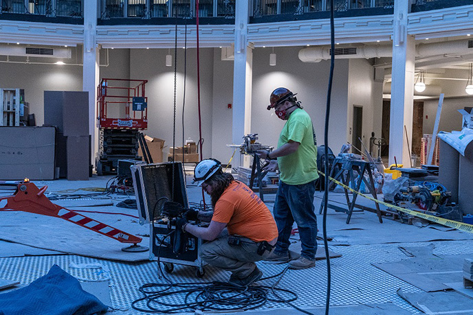 Two Scenic Solutions team members installing a theater system