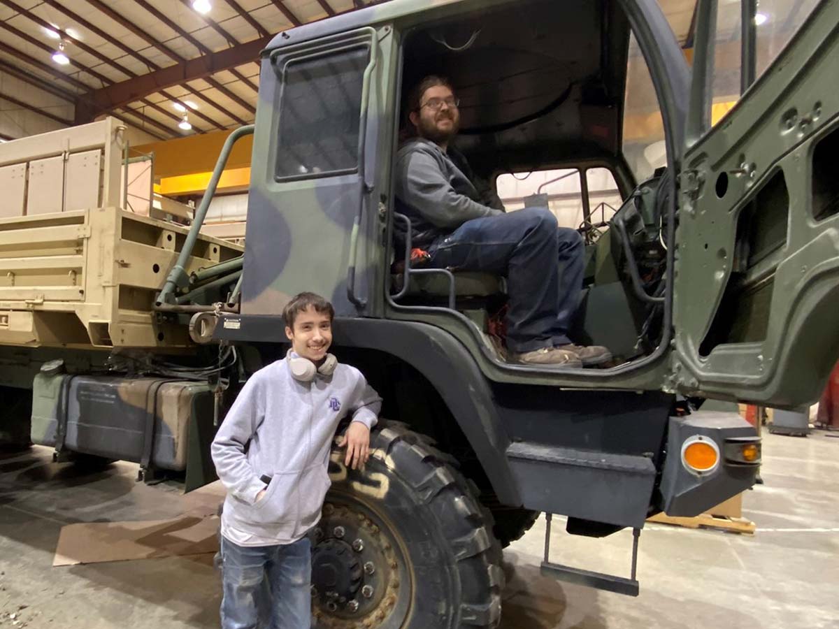 Noah and Eli smiling from a large truck