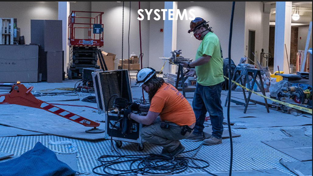 Scenic Solutions' tech team installing equipment with the text overlay, Systems
